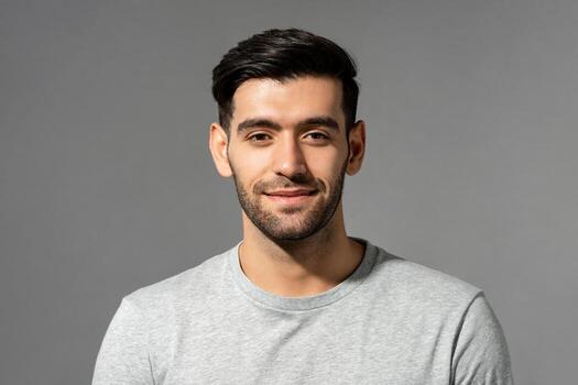 5346410 gros plan portrait de souriant beau jeune homme caucasien visage regardant camera sur fond studio gris clair isole photo